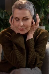 Woman wearing headphones listening to an audiobook on a sofa