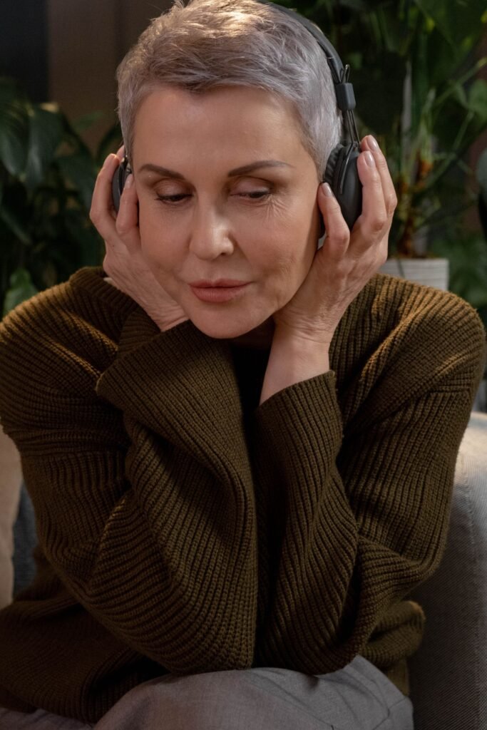 Woman wearing headphones listening to an audiobook on a sofa