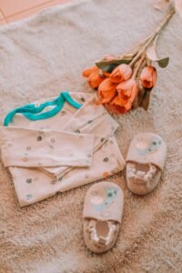Baby clothes laid out with flowers — baby registry must-haves