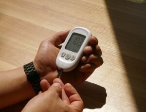 Hands holding a glucose meter for a blood sugar check