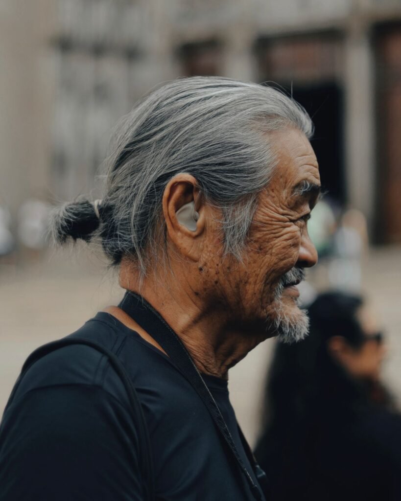 Senior man wearing a hearing aid outdoors