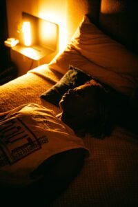 Person sleeping peacefully in a dim bedroom with a bedside sound machine for sleeping with tinnitus