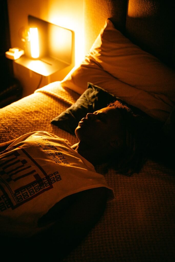 Person sleeping peacefully in a dim bedroom with a bedside sound machine for sleeping with tinnitus