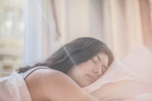 Woman sleeping peacefully in a sunlit bedroom